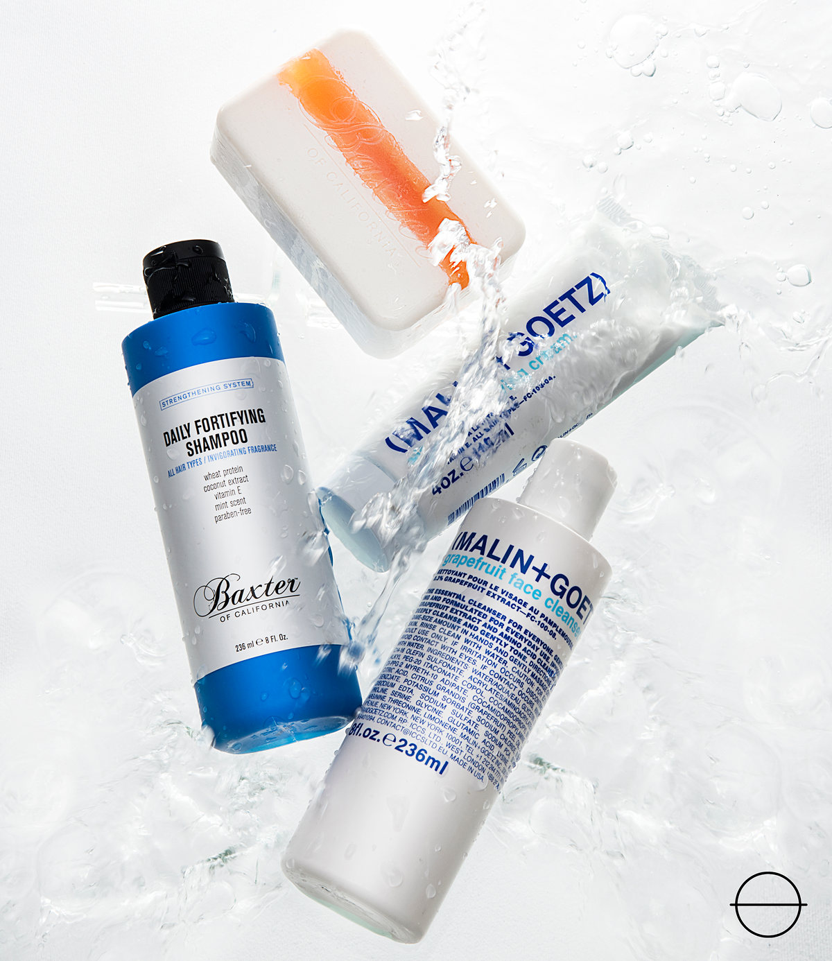 Botellas de cuidado personal Baxter of California y Malin+Goetz con salpicadura de agua