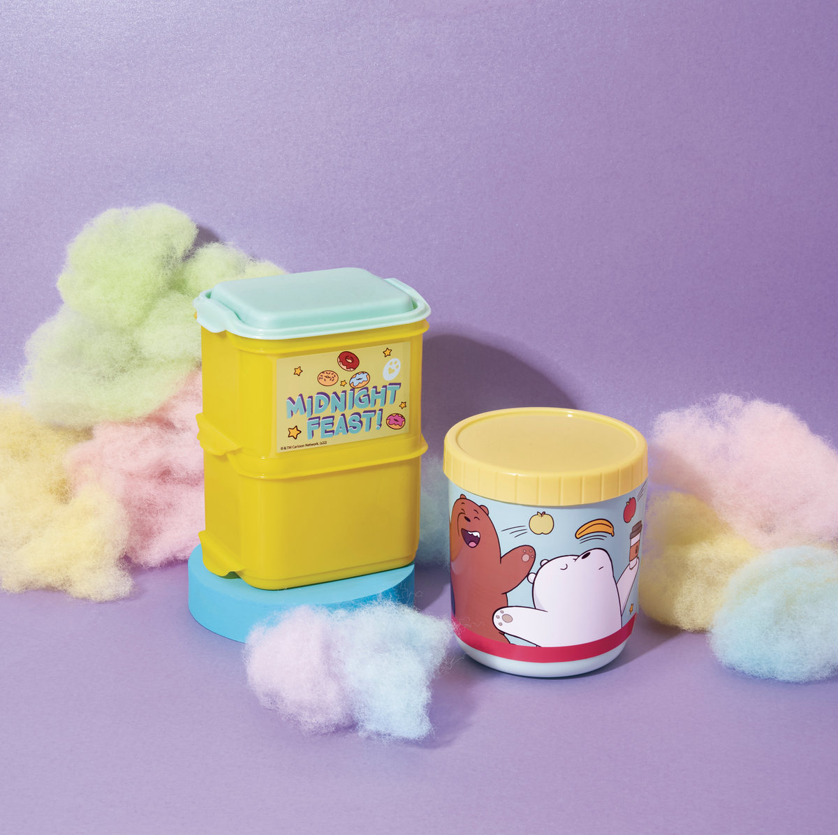 Yellow food containers among cotton candy on lilac