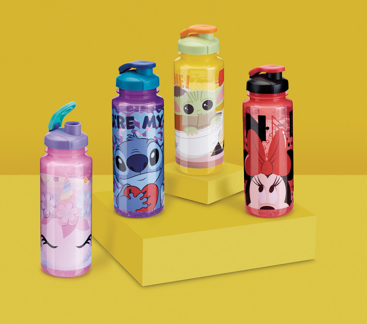 Character-themed kids' water bottles on blocks against yellow