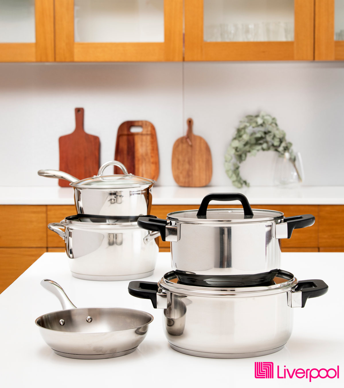 Stainless steel pots and pans on a kitchen counter, with the Liverpool logo
