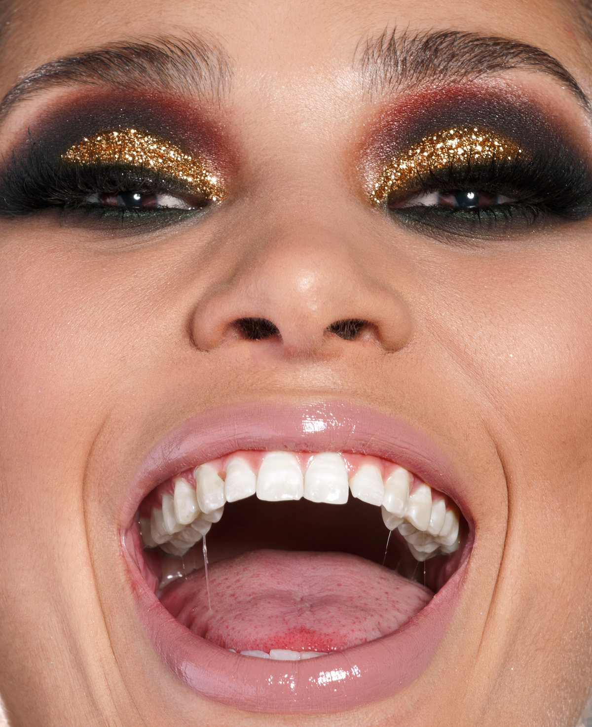 Close-up of an open mouth and gold glitter eyeshadow