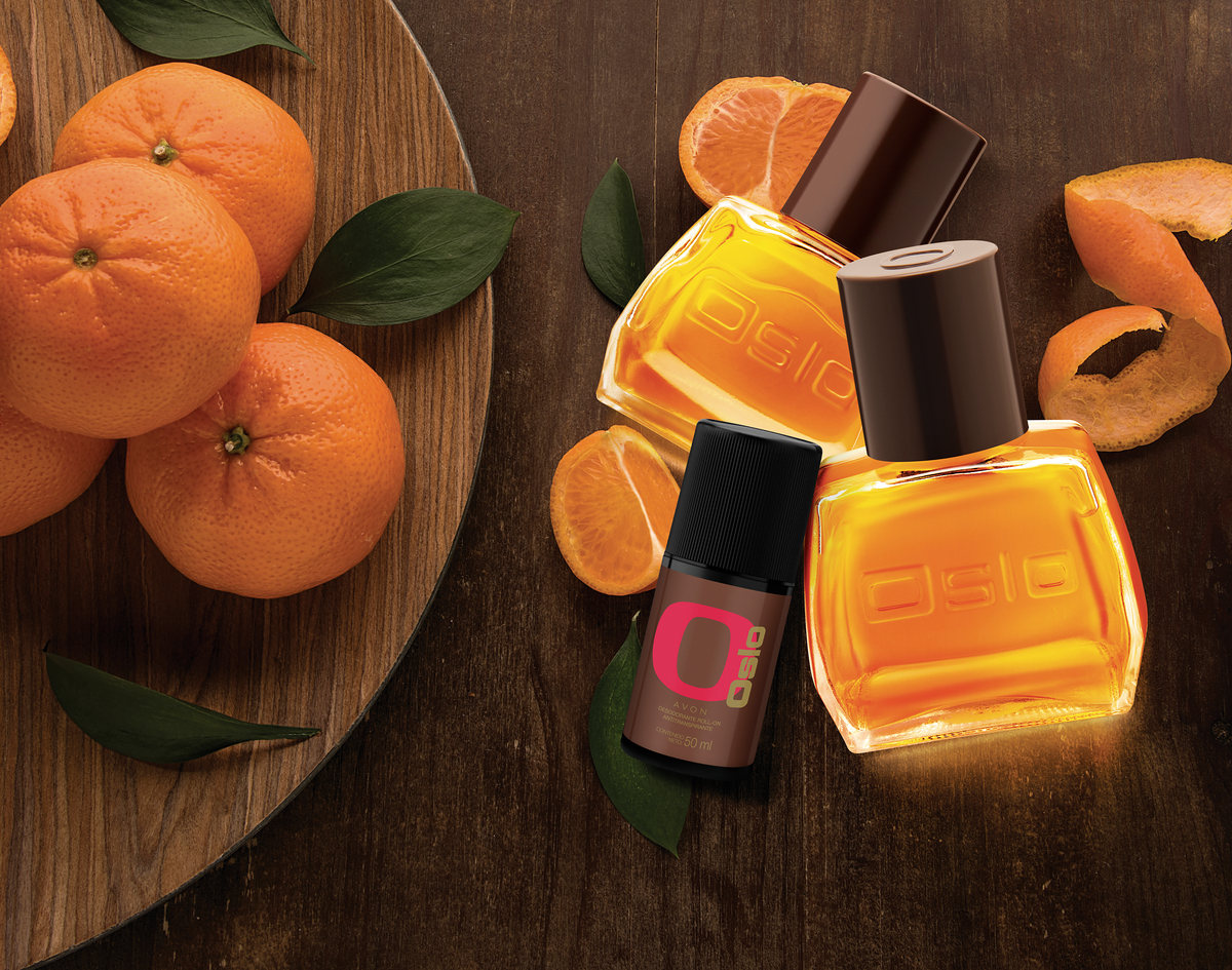 Amber fragrance bottles with mandarins and leaves on a dark wooden table