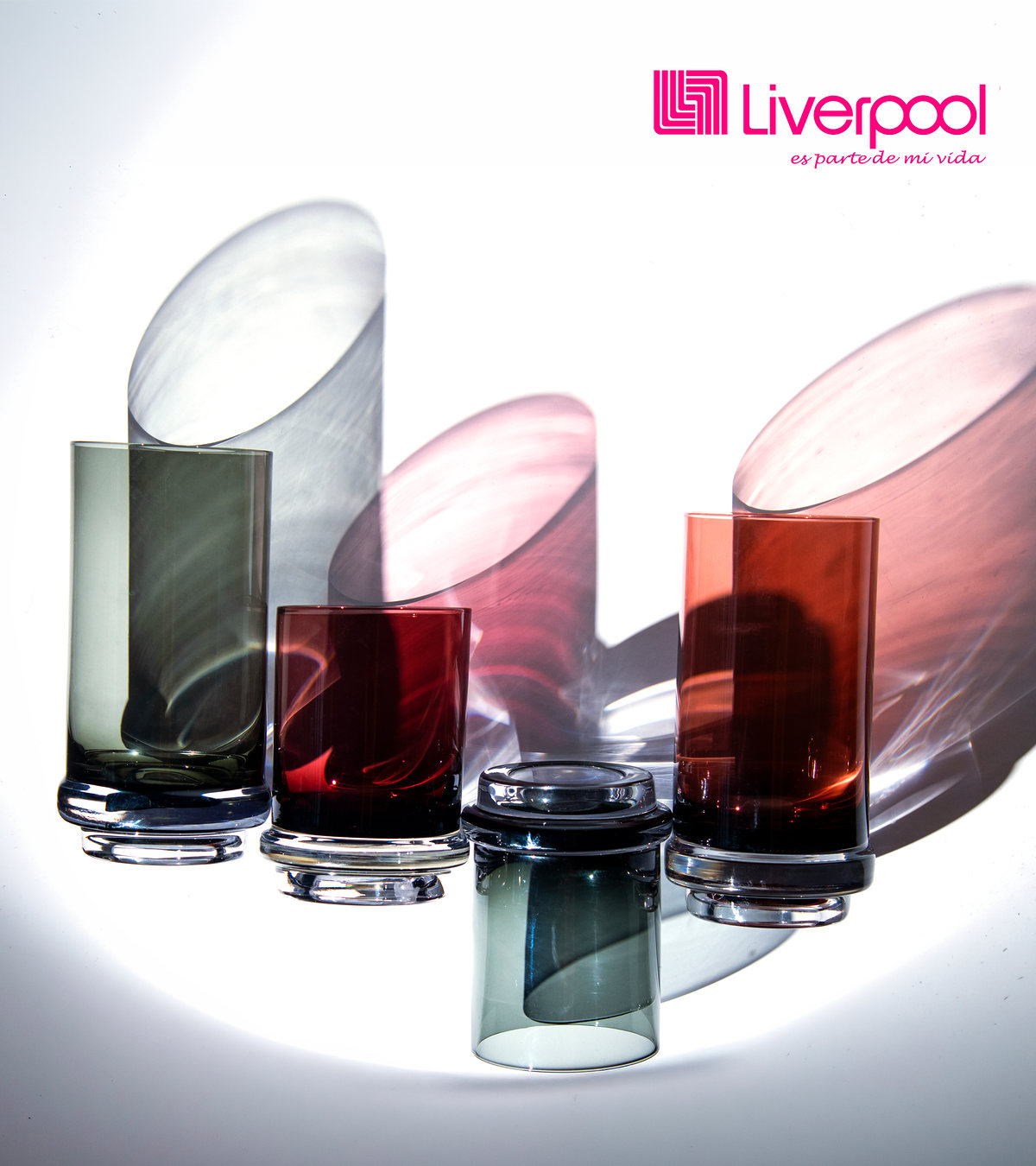 Vasos y floreros de cristal de colores con luz dramática, con logotipo de Liverpool