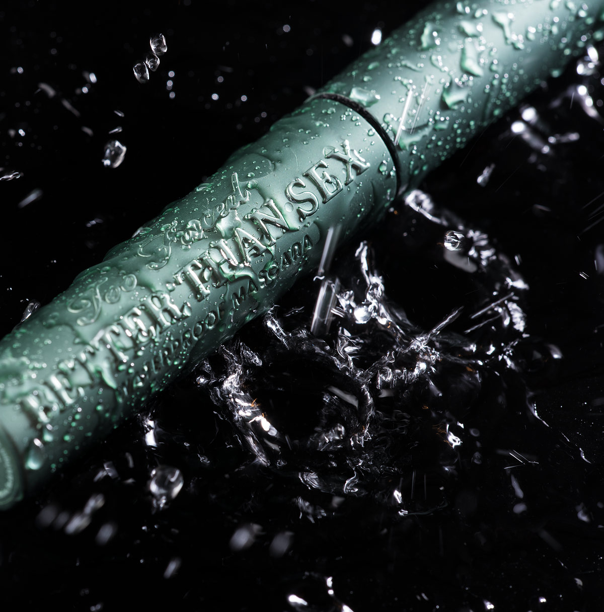 Green mascara tube covered in water droplets on black