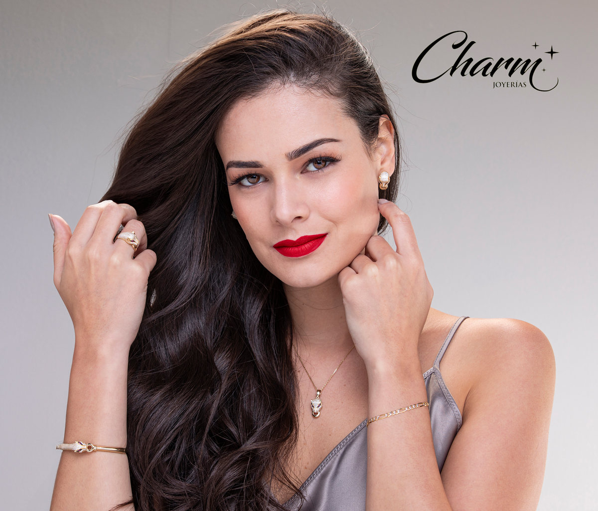 Modelo de cabello oscuro con labios rojos y joyería fina, con logotipo de Charm