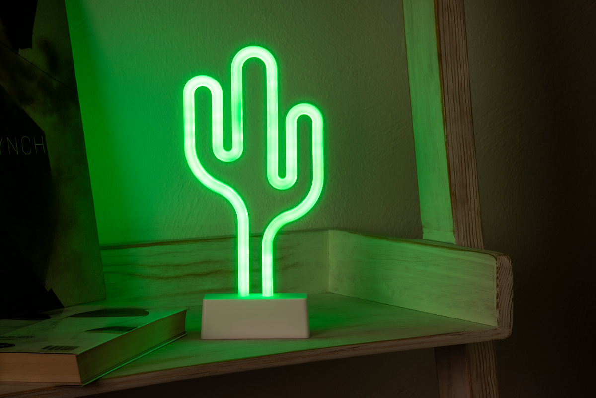 Green neon cactus lamp on a wooden shelf in low light