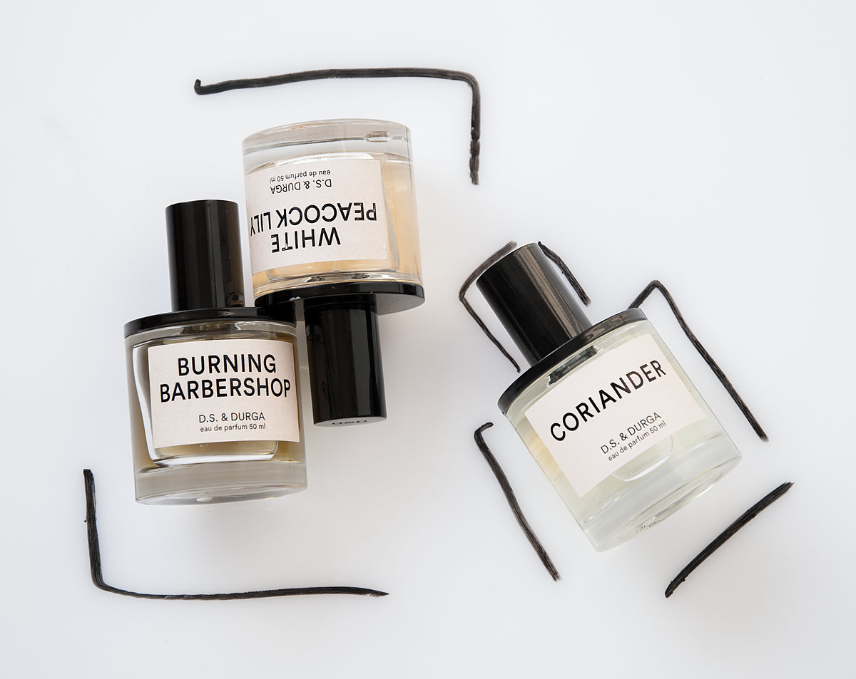D.S. & Durga perfume bottles lying on white with black strokes