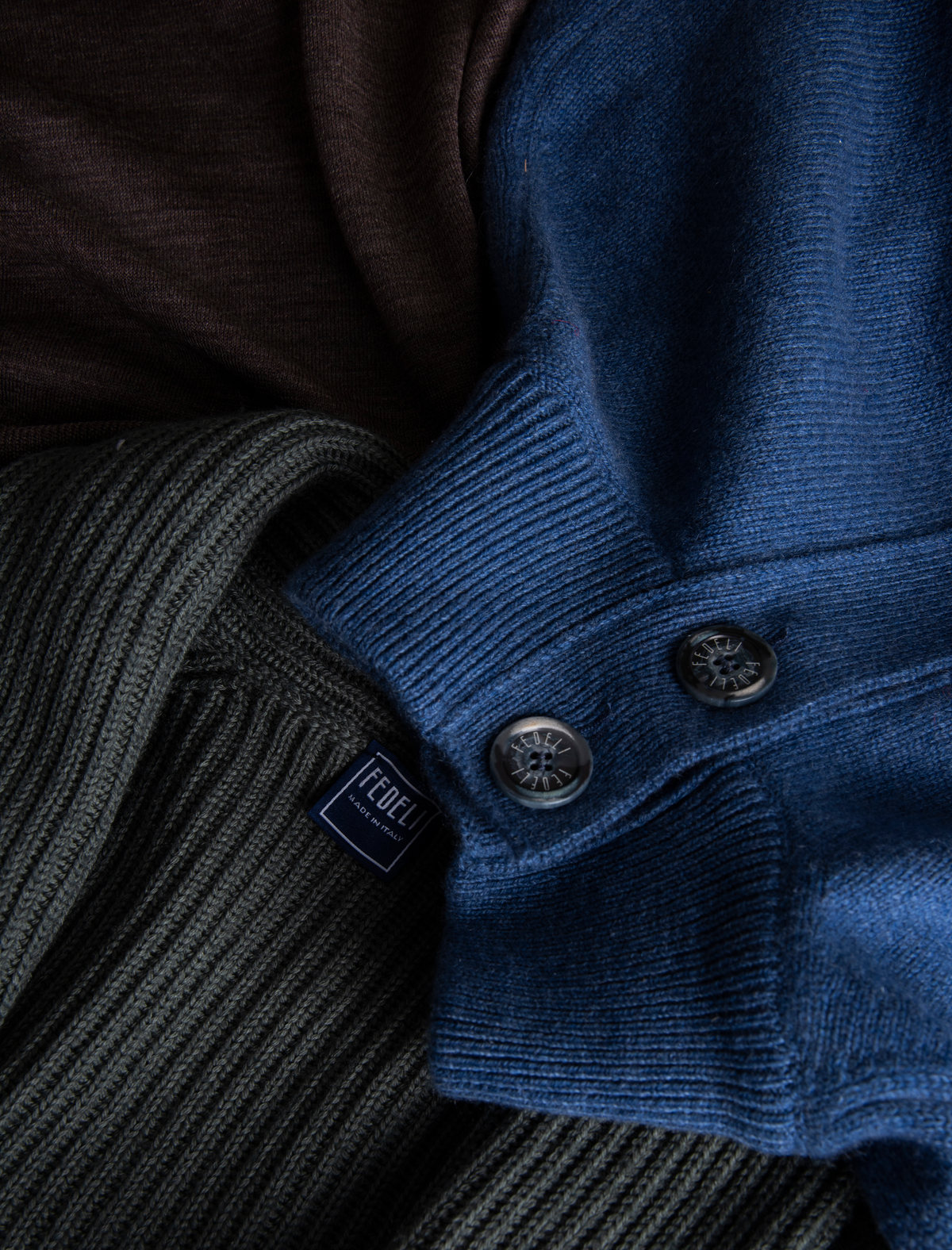 Detalle de suéteres de punto azul y gris con botones