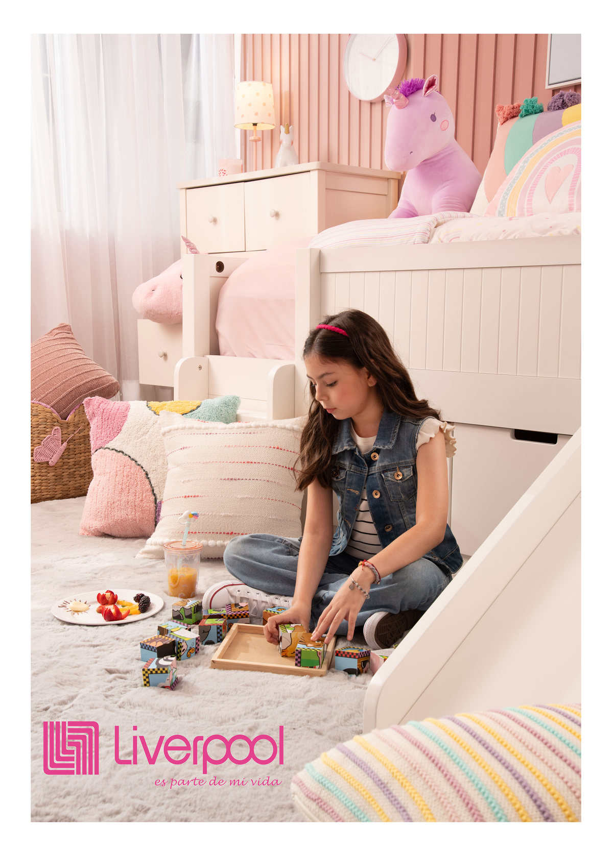 Girl playing on the floor of a pastel kids' bedroom, with the Liverpool logo