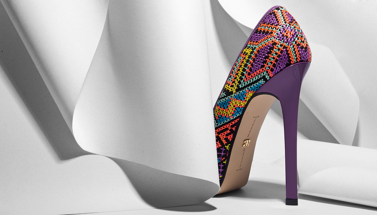 Stiletto with multicolor embroidery on folded white paper