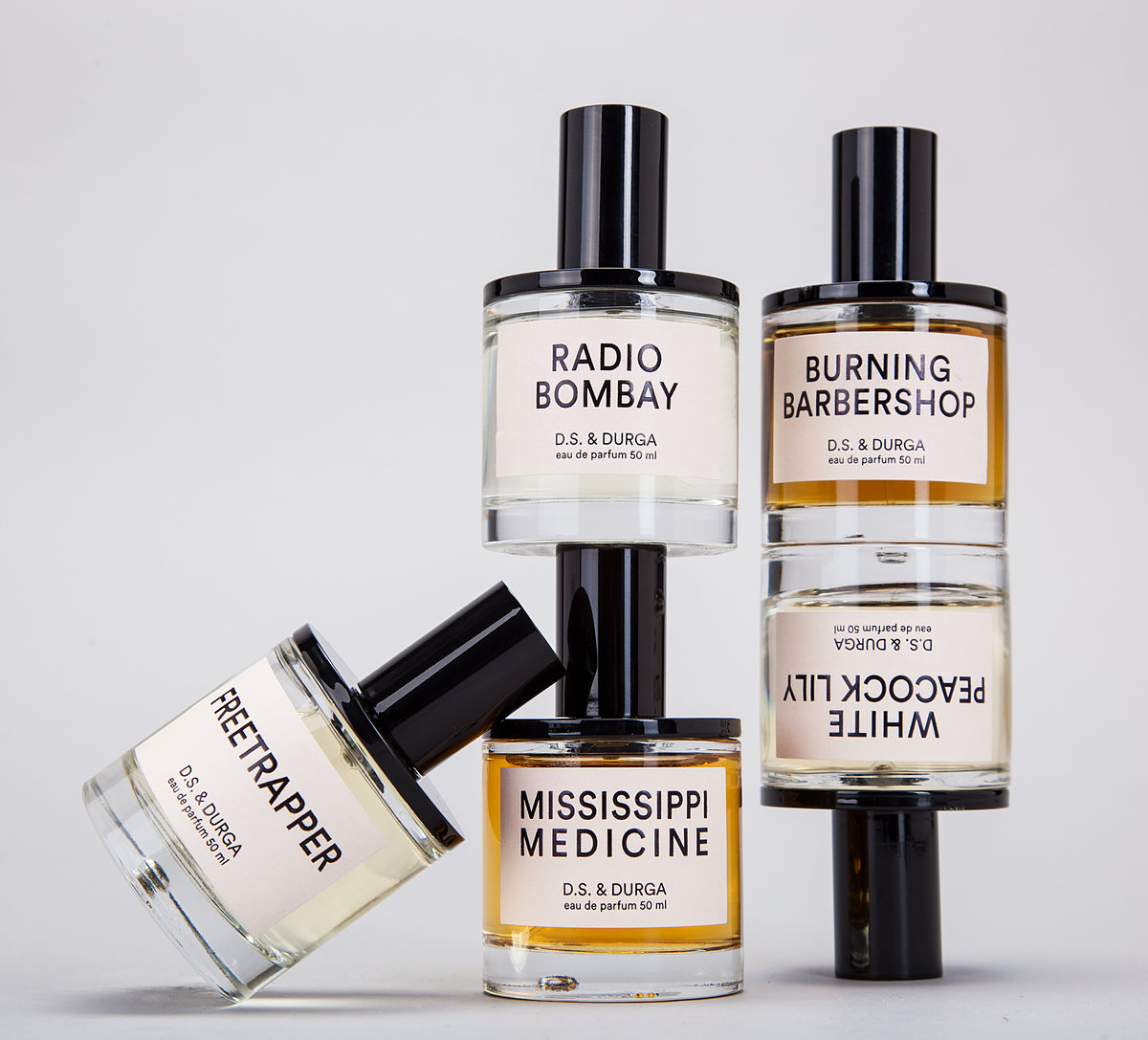 Stacked D.S. & Durga perfume bottles on light gray