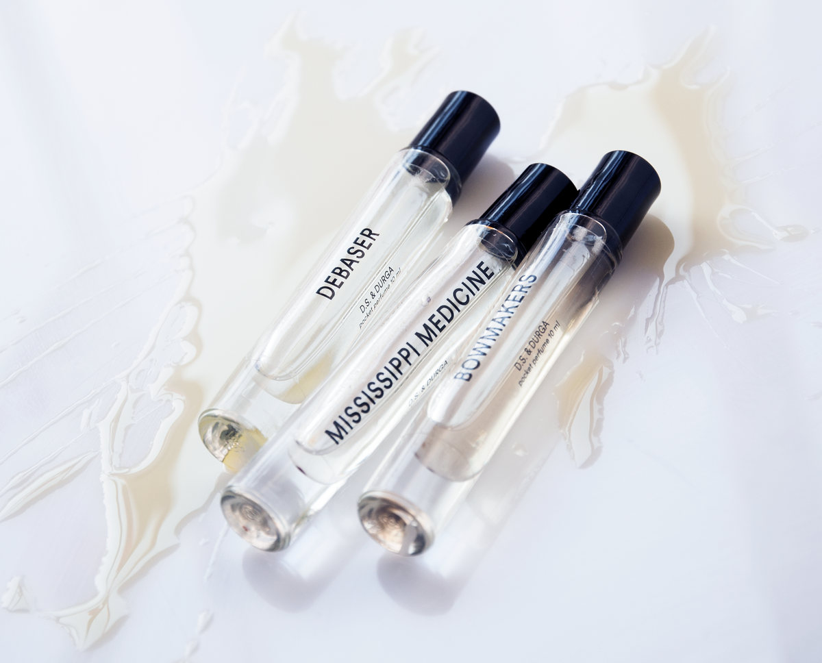 Three D.S. & Durga perfume vials on a milky splash